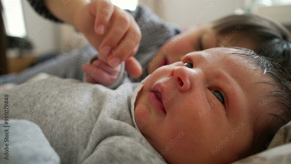 Newborn baby with attentive older brother close by, sharing a precious moment on the bed, showcasing early sibling relationship and love in a calm home atmosphere Newborn baby with attentive older brother close by, sharing a precious moment on the bed, showcasing early sibling relationship and love in a calm home atmosphere