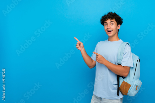 Konstfotografi Smiling boy guy high school male pupil student teenager with dental braces backpack pointing index finger empty copy space advertisement isolated on blue background
