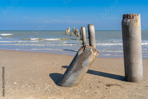 Weathered Concrete Posts on Serene Beach Landscape at Leaning Post Beach or Title pilar beach, Nong Khanan, Mueang Phetchaburi District, Phetchaburi, Thailand photo