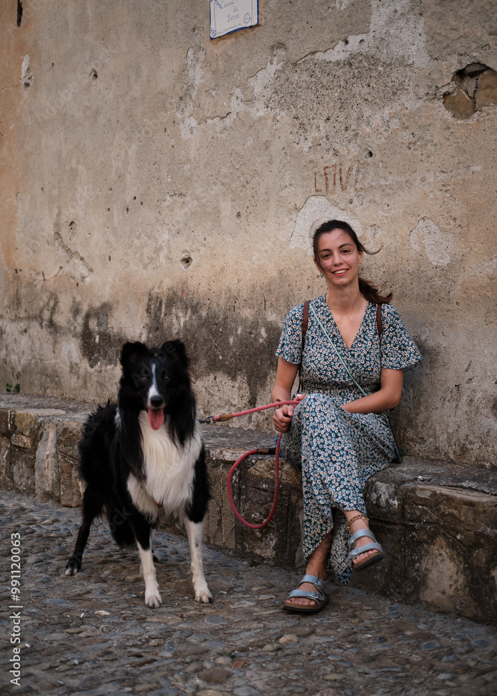 Foto scattata nel centro storico di Cervo ad una ragazza in posa con il suo cucciolo di border collie.