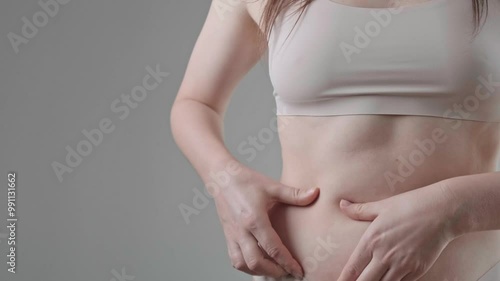 Wallpaper Mural Close-up of woman's belly holding a fat fold, weight loss through diet and exercise, focus on combating excess weight. Torontodigital.ca