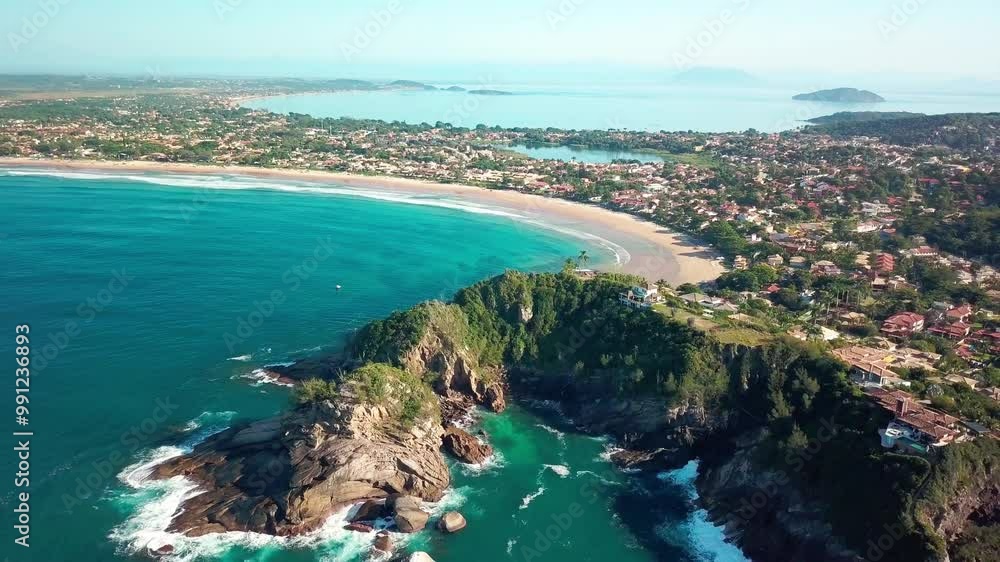 Aerial view of Geribá Beach in Búzios, surrounded by cliffs and crystal-clear waters. Aerial view of Geribá Beach in Búzios, surrounded by cliffs and crystal-clear waters.