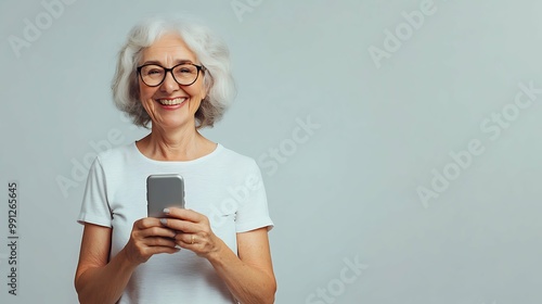 Photo of senior lady hold telephone look in camera wear eyeglasses white t-shirt isolated grey color background