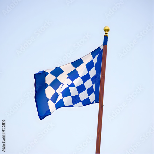 Bright blue and white checkered flag waving on a pole against clear sky