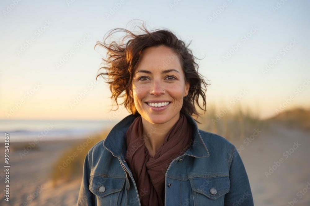 Portrait of a happy woman in her 30s sporting a rugged denim jacket in front of serene dune landscape background Portrait of a happy woman in her 30s sporting a rugged denim jacket in front of serene dune landscape background