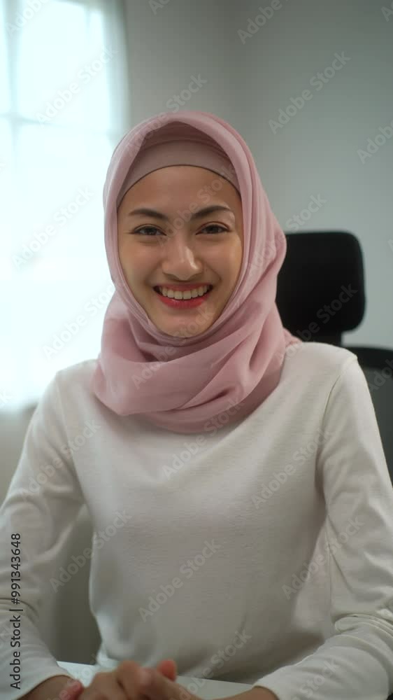 Vertical video shot of young beautiful muslim woman speaking to camera for business meeting video call conference with team online at home office, smiling female doing interview video call online.
Vertical video shot of young beautiful muslim woman speaking to camera for business meeting video call conference with team online at home office, smiling female doing interview video call online.