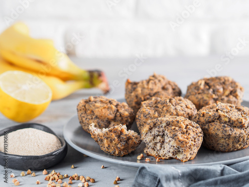 Close-up view of healthy gluten-free homemmade banana muffins with buckwheat flour. Vegan muffins with poppy seeds on gray plate over gray wooden table. Copy space