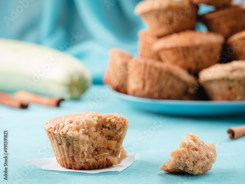 Close up view of muffin with zucchini, carrots, apple and cinnamon on blue concrete background. Sweet vegetables homemade muffins. Toddler-friendly recipe idea. Copy space. Shallow DOF