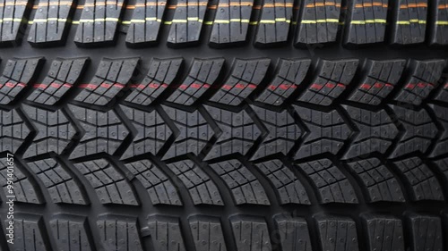 New winter tire rotation close-up, highlighting tread pattern for enhanced grip and safety on icy roads. Perfect for automotive maintenance, winter driving, and safety concepts.