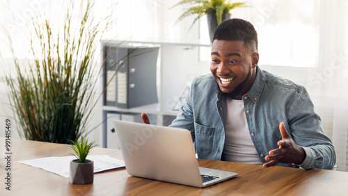 Tableau sur toile Happy black businessman looking at laptop screen, excited by reading good news o