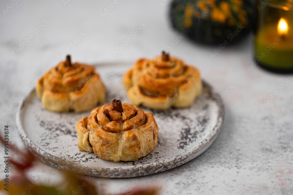 Pumpkin cinnamon rolls. Fresh homemade Cinnamon Rolls in the form of pumpkins. Bakery for Halloween or Thanksgiving party. Cozy autumn, winter still life with pumpkins.