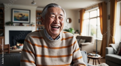 Laughing elderly Asian man wearing a sweater in a living room during a family gathering