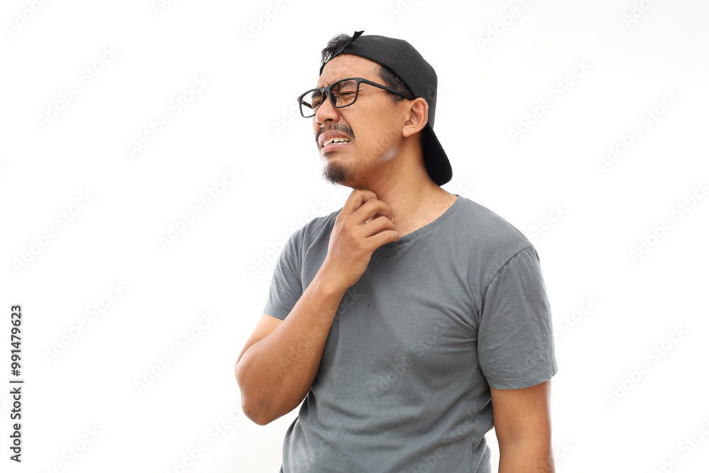 Fototapeta premium Asian man with beard wearing casual t-shirt and glasses Touching painful neck, sore throat for flu, cold and infection. Isolated white background