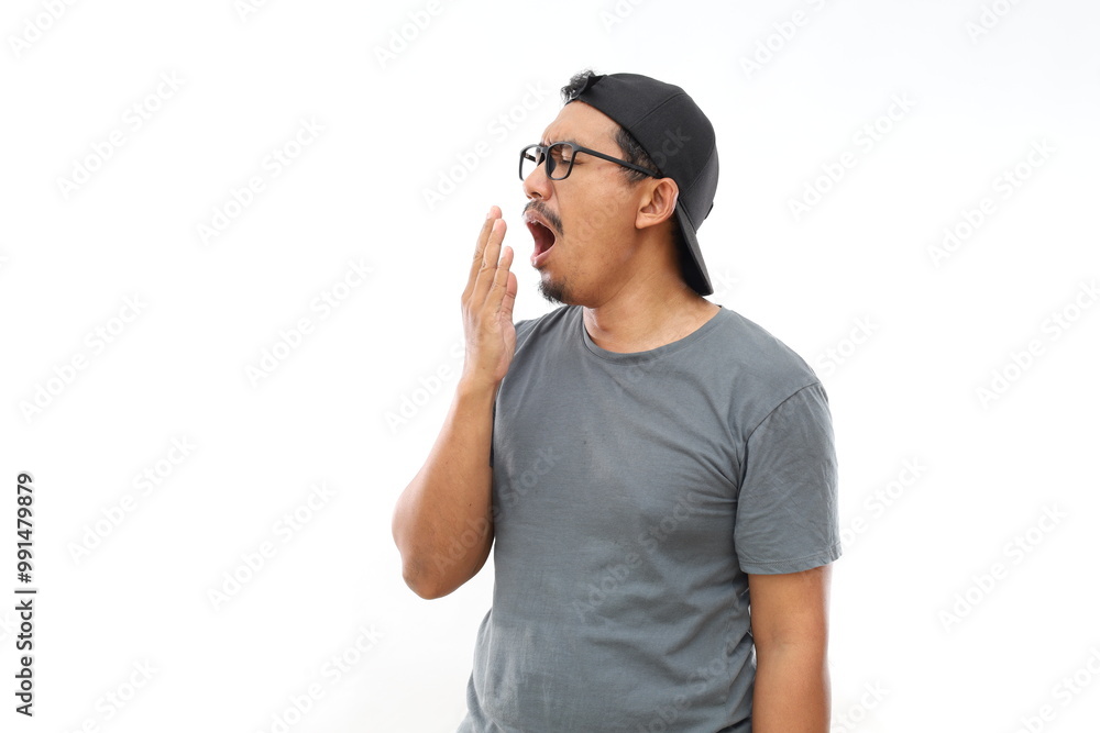 Bored tired Asian man yawning covering mouth with hand. Restless and sleepiness. Bored tired Asian man yawning covering mouth with hand. Restless and sleepiness.