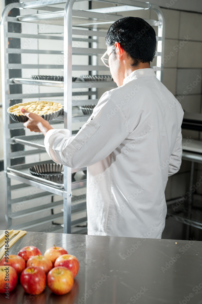 Bakery industry worker places the prepared product on an aluminum shelf. Bakery industry worker places the prepared product on an aluminum shelf.