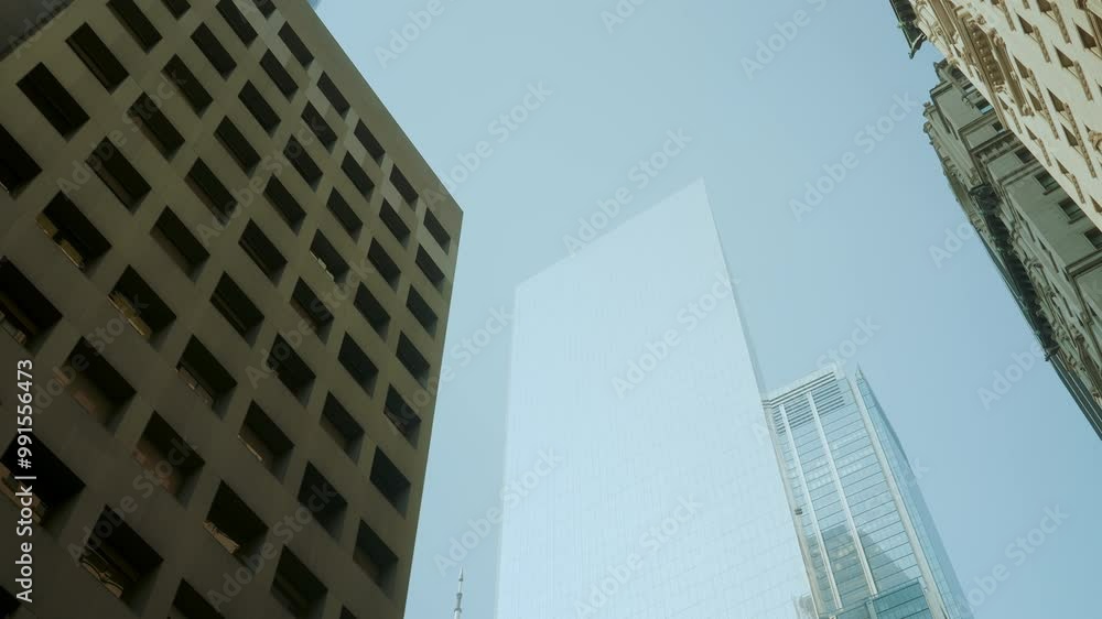 Wide shot looking up the Manhattan office buildings and glass skyscrapers on a sunny cloudless day. Driving in the Midtown Manhattan in New York. Wide shot looking up the Manhattan office buildings and glass skyscrapers on a sunny cloudless day. Driving in the Midtown Manhattan in New York.