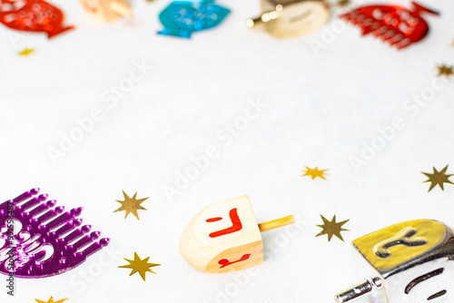 Hanukkah Jewish design. Wooden dreidel toys, stars decoration on white background. Top view. photo