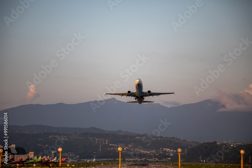 Beautiful airplane takes off at sunset. Sunny evening. Large passenger plane. photo