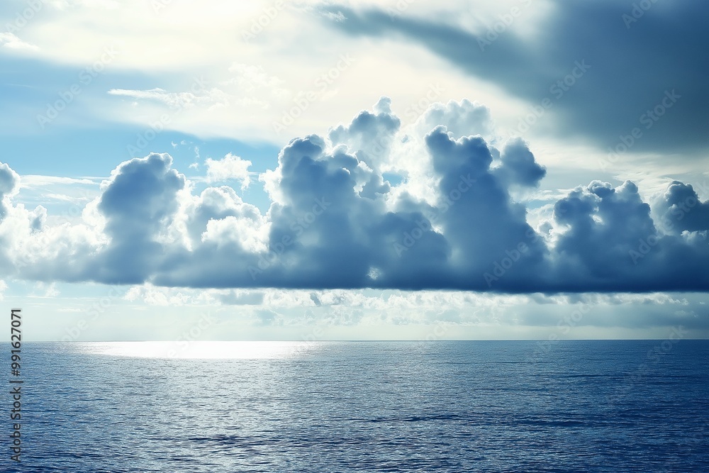 Naklejka premium A breathtaking view of the ocean with expansive, dramatic clouds floating above, capturing nature's vast beauty.