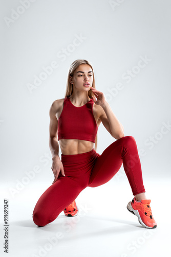 Sexy fitness woman. Beautiful athletic girl, isolated on the gray background