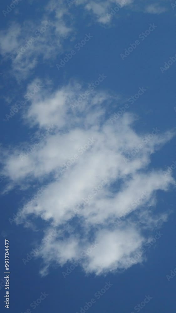 Light translucent clouds move from right to left and dissipate, transform in flight in the air against the blue sky. Vertical Full HD Video with 25 fps. Blank for the background.