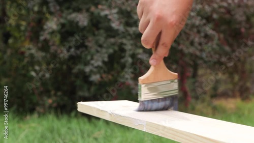 The carpenter treats the board with insecticide and applies varnish to the board.