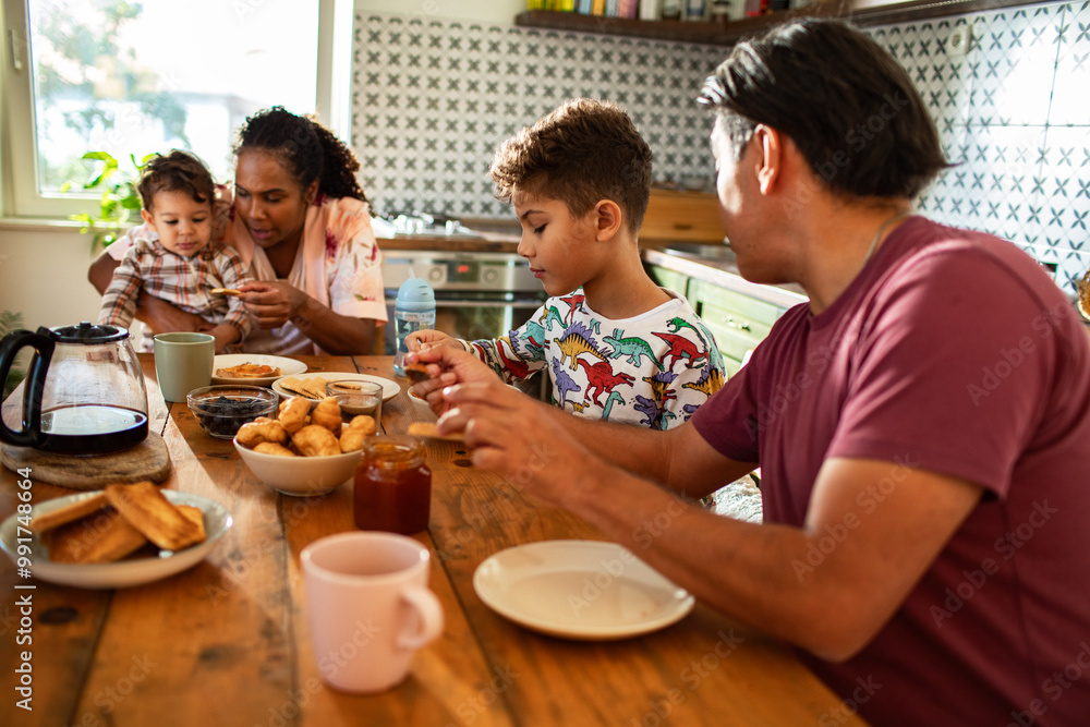 Family breakfast time with kids and parents at kitchen table Family breakfast time with kids and parents at kitchen table