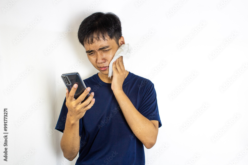 a teenager who is feeling pain in his gums and is looking at his cellphone
