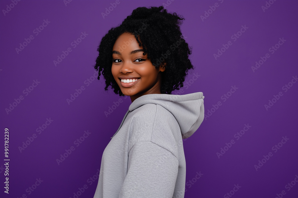 Student in hoodie and sweatpants against purple background with confident smile Student in hoodie and sweatpants against purple background with confident smile
