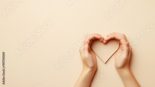 Hands forming a heart shape on a beige background.