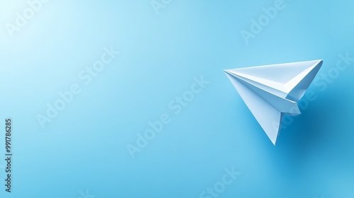 A white paper airplane on a blue background, representing a simple and creative concept.