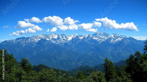  A stunning view of majestic mountains, framed by lush trees in the foreground and a captivating blue sky adorned with fluffy clouds in the backdrop