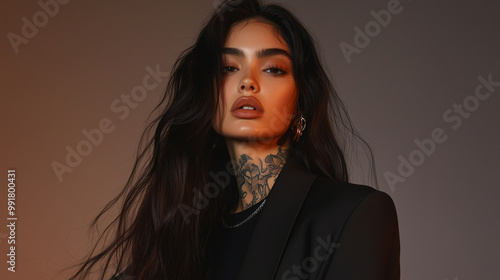 A fierce Hispanic model with a rebellious edge, her long hair cascading over her shoulders, tattoos peeking out from under her black t-shirt and blazer, glowing softly against a mo photo