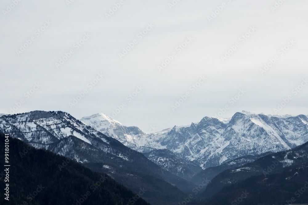 Snow-covered mountains against the background of gray clouds. Winter in Austria Snow-covered mountains against the background of gray clouds. Winter in Austria