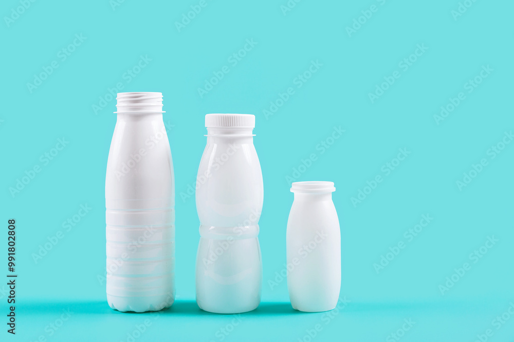 White plastic bottles standing against a blue backdrop, presenting a vibrant contrast and drawing attention to eco-friendly packaging solutions. White plastic bottles standing against a blue backdrop, presenting a vibrant contrast and drawing attention to eco-friendly packaging solutions.