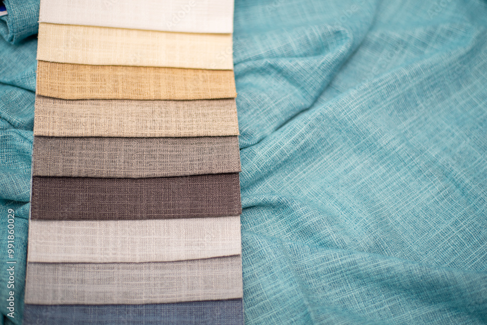 Beige and gray samples of fabrics for curtains on a turquoise background. Linen fabric. Beige and gray samples of fabrics for curtains on a turquoise background. Linen fabric.
