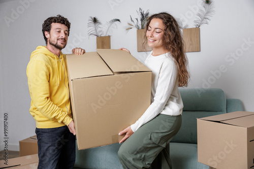 Young and happy couple move boxes to move into their new residence. Life is about beginnings. Paying mortgage for many years. Together everything is easier