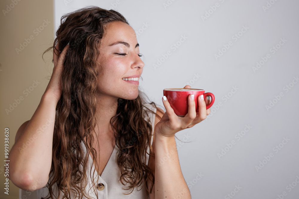 Portrait of young woman drinking coffee in a cafe. Enjoying its aroma. Nothing like a good coffee in the morning. Dose of caffeine. Enjoying moments alone with oneself. Portrait of young woman drinking coffee in a cafe. Enjoying its aroma. Nothing like a good coffee in the morning. Dose of caffeine. Enjoying moments alone with oneself.