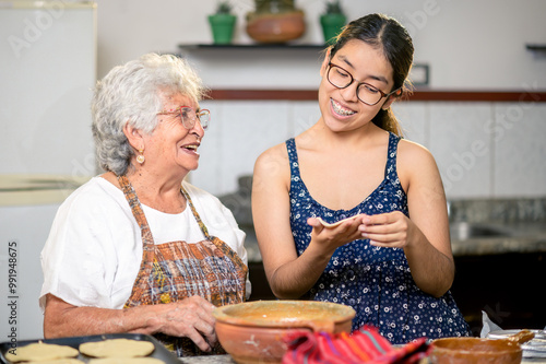 Wallpaper Mural Grandma is happy to show her granddaughter how to make corn tortillas. Torontodigital.ca