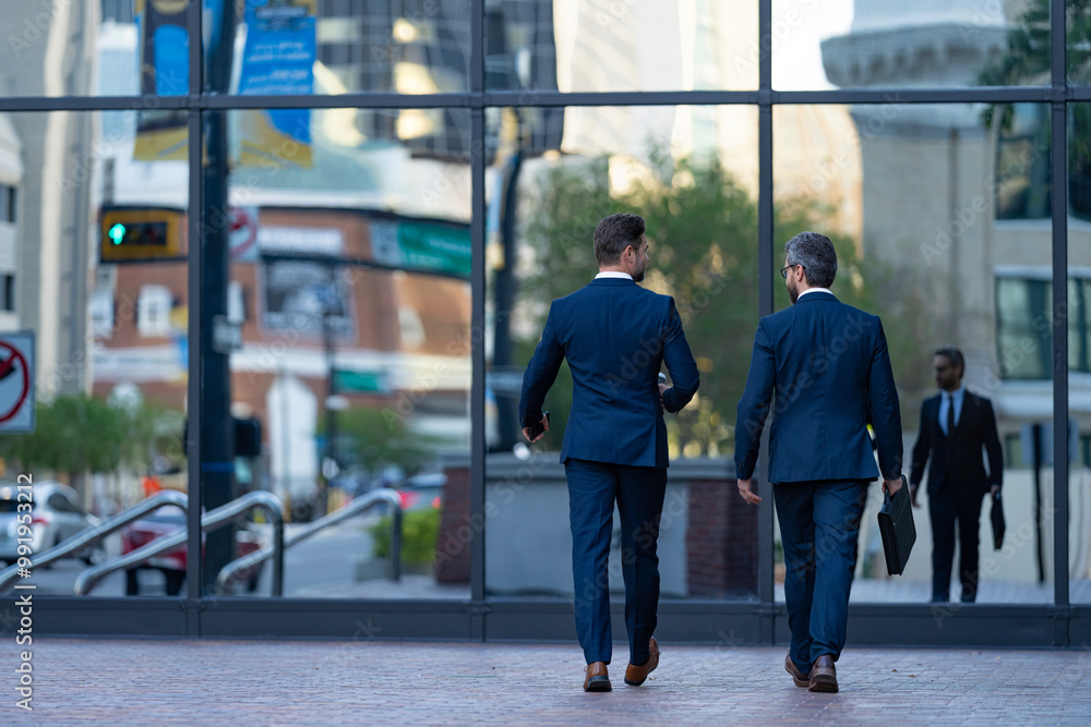 Colleague and friends. Two successful business men walking outdoor. Businessmen go to work. Business talking. Two businessmen in elegant business suit. Walking colleague. Modern city