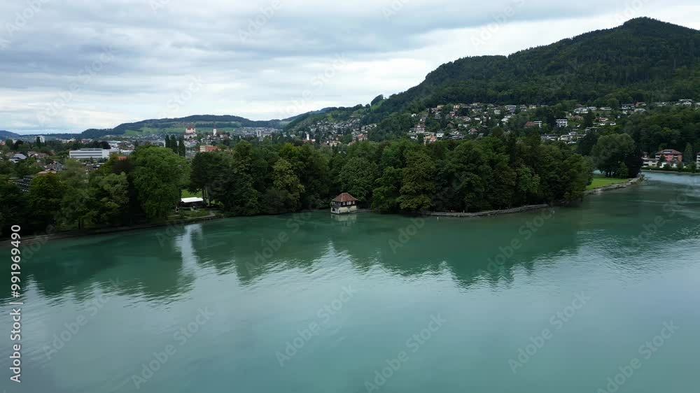 Crane drone shot of a small house next to Thun Lake in the Canton of Bern in Switzerland. Crane drone shot of a small house next to Thun Lake in the Canton of Bern in Switzerland.