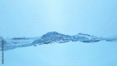 Clean sparkling water creates waves and water bubbles as it moves in a container.