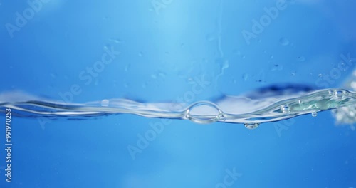 Waves of sparkling water, create some bubbles and droplets in a container.