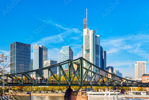 Картината върху платно Frankfurt Main Iron footbridge against financial district skyscrapers with blue sky