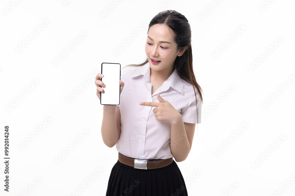 Portrait pretty Asian student girl in Thai university uniform pointing finger to mobile smart phone screen isolated on white background. Portrait pretty Asian student girl in Thai university uniform pointing finger to mobile smart phone screen isolated on white background.
