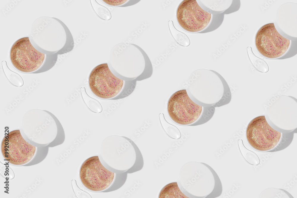 Pattern of hydrogel patches for moisturizing and nourishing the skin around the eyes. Cosmetic product in a jar on white background. Minimal cosmetic product concept Pattern of hydrogel patches for moisturizing and nourishing the skin around the eyes. Cosmetic product in a jar on white background. Minimal cosmetic product concept