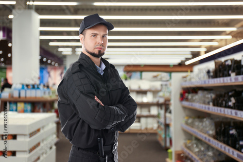 Confident security guard wearing uniform in supermarket photo