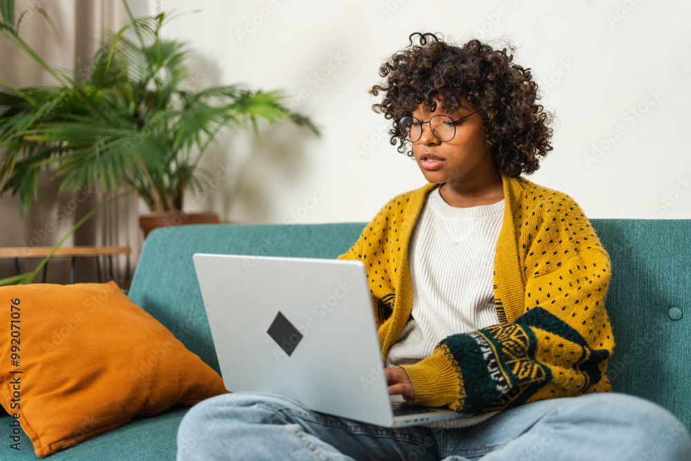 African American girl using laptop at home office typing chatting reading writing email. Young black woman having virtual meeting online chat video call conference. Work learning from home African American girl using laptop at home office typing chatting reading writing email. Young black woman having virtual meeting online chat video call conference. Work learning from home