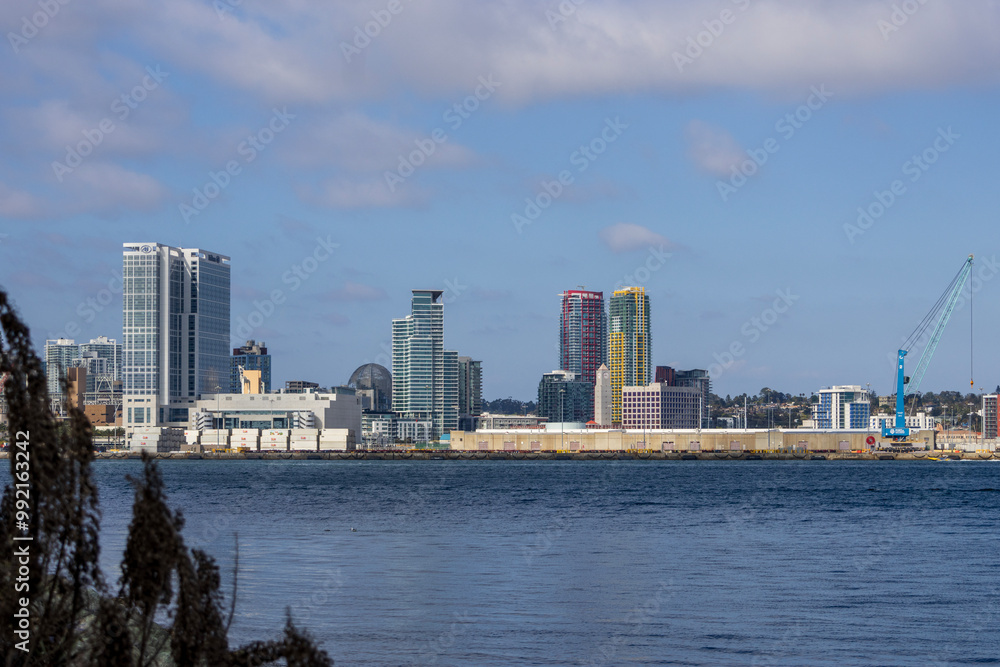 Fototapeta premium skyscrapers, office buildings, the San Diego Convention Center and cranes along the coast of the San Diego Bay at Coronado Tidelands Park in Coronado California USA