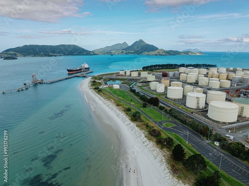 Petroleum tanker, coastline and storage silos at the decomissioned Marsden Point Refinery, Whangarei, Northland, New Zealand. photo